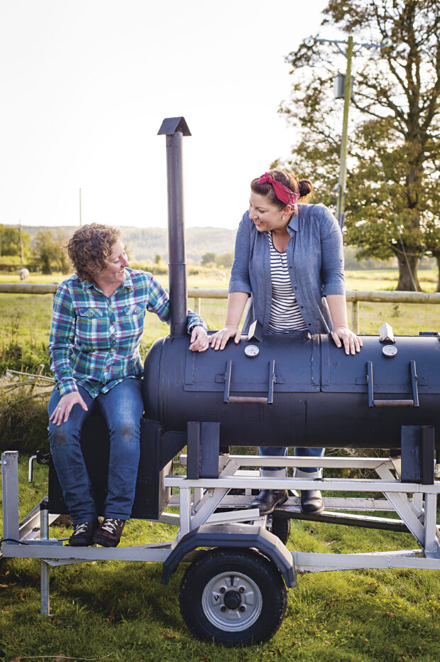 Sam and Shauna by their smoker in a field