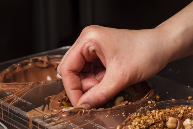 A person's hand making Easter eggs. 