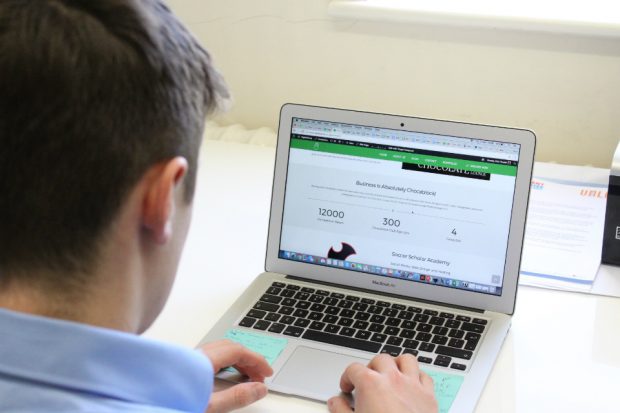 Carl typing on a computer displaying his website