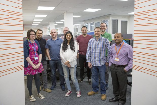 The team standing up and smiling in the Companies House Cardiff office. 