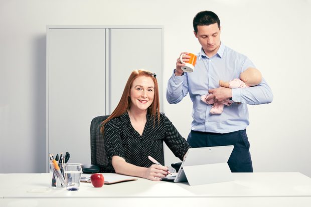 Image of mother at a computer and father holding a baby.