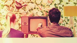 Couple watching TV in typical 1970s setting