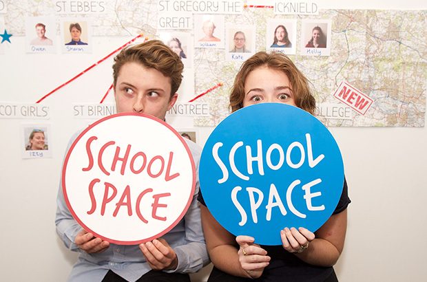 Two students posing behind signs saying 'School Space'