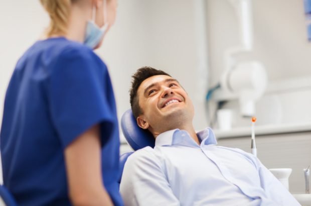 Female dentist with smiling male patient.