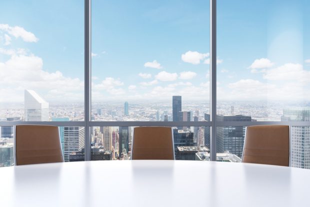 Boardroom in a skyscraper with city view.