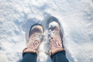 A pair of female boots in the snow.