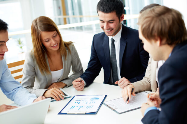 Business partners discussing documents at meeting.