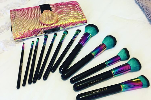 Makeup brushes laid out on a bed