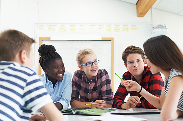 Group of teenage students working together in a classroom