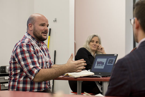 A man talking to his colleagues and using hand gestures.