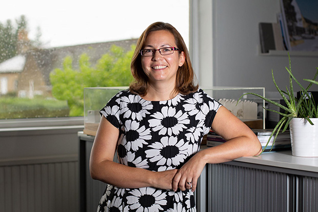 A person standing up and smiling at the camera.