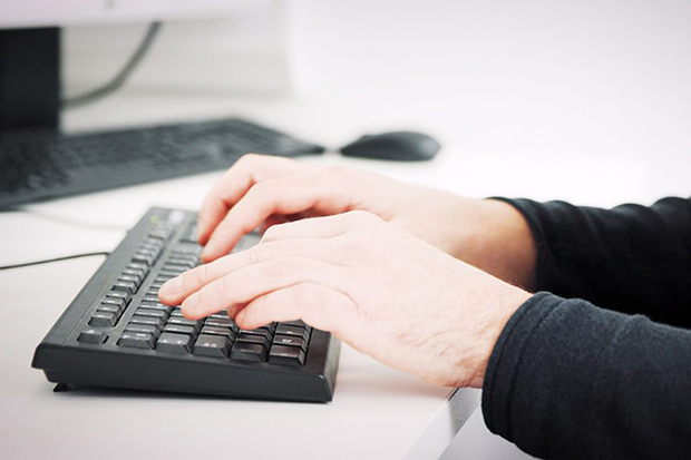 Hands working on a keyboard.