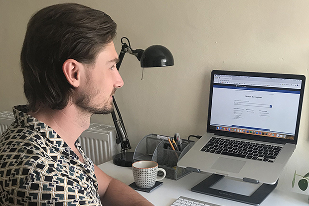 A person sat at a desk working on a laptop.