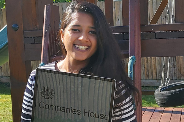 A lady standing outside holding a laptop with 'Companies House' displayed on the screen.