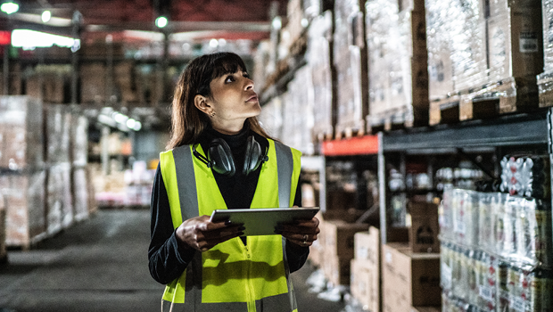 An employee wearing a high-vis jacket working in a warehouse.
