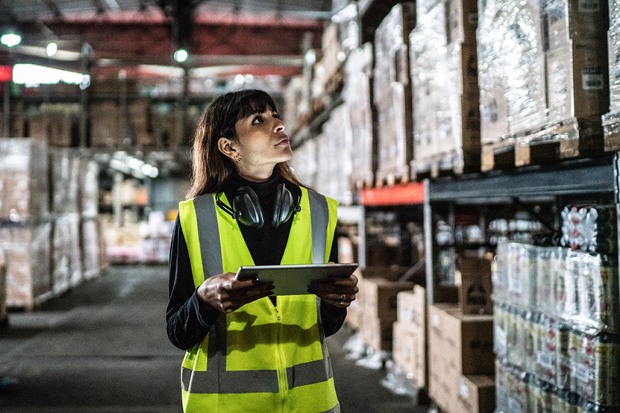 An employee wearing a high-vis jacket working in a warehouse.